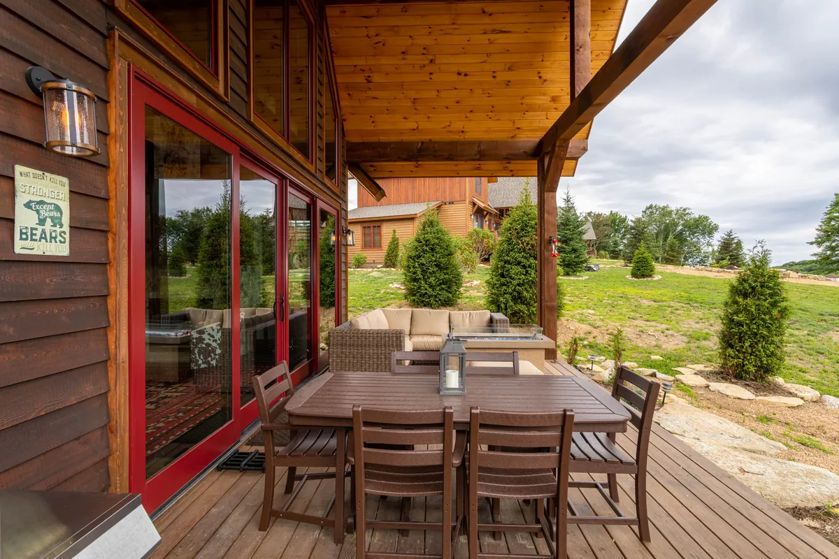 A cozy outdoor dining table and comfortable seating area are nestled within a manicured garden. The setup invites sunset dinners, morning coffee rituals, or simply unwinding while soaking up the fresh mountain air.